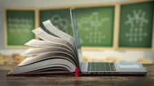E-learning online education or internet encyclopedia concept. Open laptop and book compilation in a classroom.